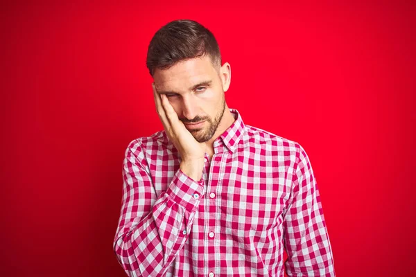 Genç ve yakışıklı bir adam soyutlanmış arka planda yaşıyor. Kollarını kavuşturarak depresyondan sıkılmış ve yorgun görünüyor..