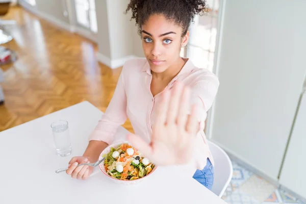 若いアフリカ系アメリカ人の女性は オープンハンドで健康的なパスタサラダを食べて 真剣で自信を持った表現 防衛ジェスチャーで停止サイン — ストック写真