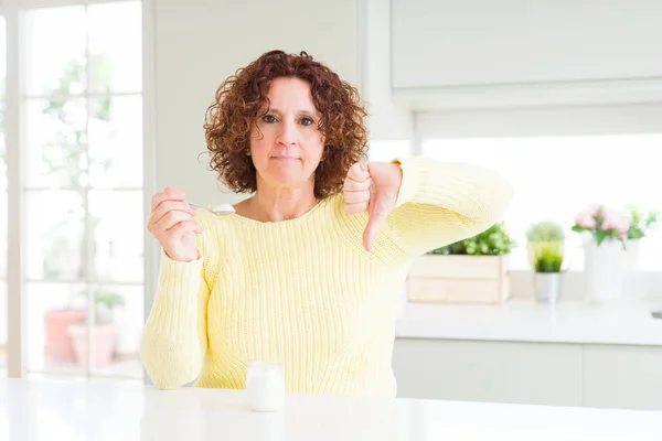 Senior Kvinna Äter Hälsosam Naturlig Yoghurt Hemma Med Argt Ansikte — Stockfoto