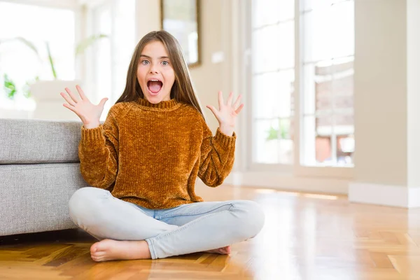 Güzel genç kız çocuk evde katta oturan deli ve başarı için hayran kaldırdı Kollarını açarak kutluyor ve heyecanlı çığlık gözleri açık. Kazanan kavramı