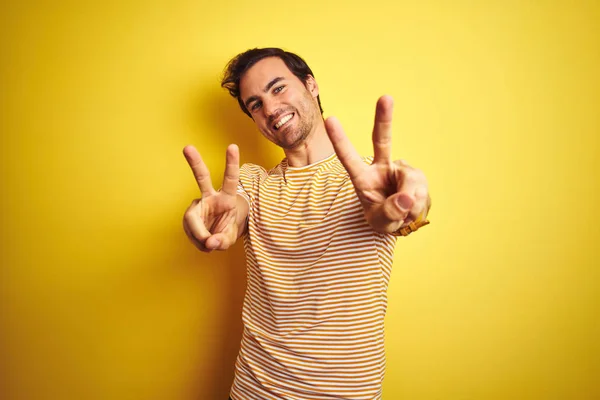Mladý Pohledný Muž Tetováním Pruhovaném Tričku Izolovaném Žlutém Pozadí Usmívající — Stock fotografie