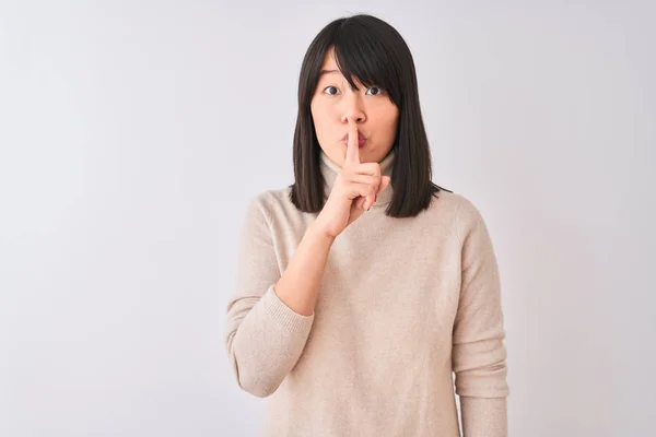 年轻美丽的中国女人穿着高领毛衣 披着孤立的白色背景 要求保持安静 手指放在嘴唇上 沉默和秘密概念 — 图库照片
