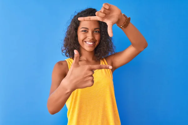 Jovem Brasileira Vestindo Camiseta Amarela Sobre Fundo Azul Isolado Sorrindo — Fotografia de Stock