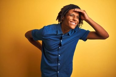 Rastgele kot gömlekli Afro adam izole edilmiş sarı arka planda dikiliyor. Çok mutlu ve gülümsüyor. Konsept aranıyor.