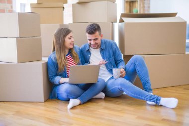 Genç çift c kullanarak karton kutular etrafında katta oturan