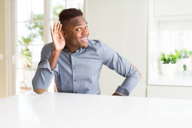 Beyaz masadaki yakışıklı afro-amerikan adam, kulağı kulaklarında dedikodu ve dedikoduları dinliyor. Sağırlık kavramı.