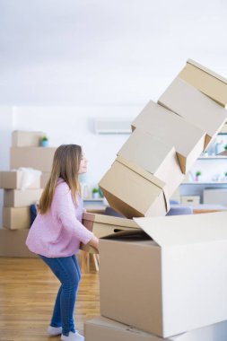 Genç bir kadın yeni bir daireye taşınıyor, elinde bir yığın kartpostal var.