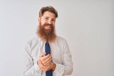 Genç kızıl saçlı İrlandalı işadamı, izole edilmiş beyaz arka planda el ele tutuşmuş ve mutlu bir şekilde gülümsüyor. Başarı ve iyimser