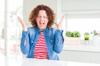 Orta yaşlı, kıvırcık saçlı, kot ceketli, çılgın ve başarıyı kollarını kaldırıp heyecanla bağırarak kutlayan son sınıf öğrencisi bir kadın. Kazanan konsept