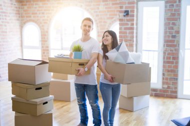 Young beautiful couple sitting on the floor at new home around cardboard boxes skeptic and nervous, disapproving expression on face with crossed arms. Negative person.