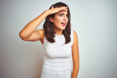 İzole edilmiş beyaz arka plan üzerinde duran elbiseler giyen genç ve güzel bir kadın çok mutlu ve tebessüm ediyor. Konsept aranıyor.