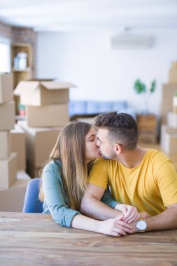 Genç güzel çift evde masada oturan, sarılma 