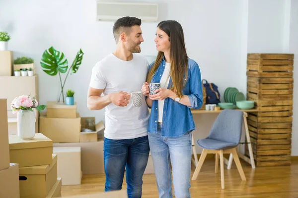 Mooi paar verhuizen naar een nieuw huis, glimlachend vrolijk Drinkin — Stockfoto