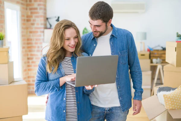 Young couple using computer laptop standing on a room around car