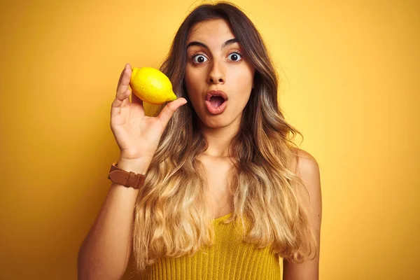 Joven Hermosa Mujer Comiendo Limón Sobre Fondo Amarillo Aislado Asustado —  Fotos de Stock