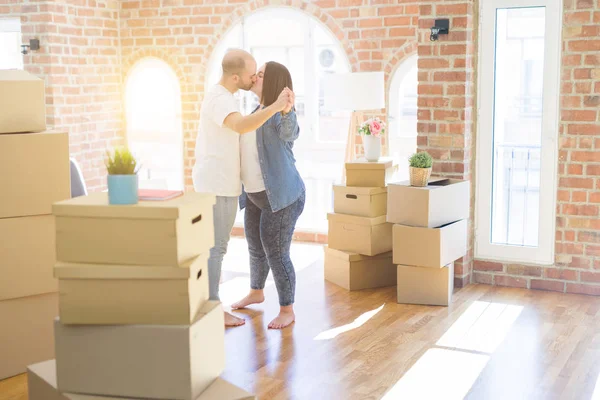 Young couple dancing around cardboard boxes at new home, celebra — Stock Photo, Image