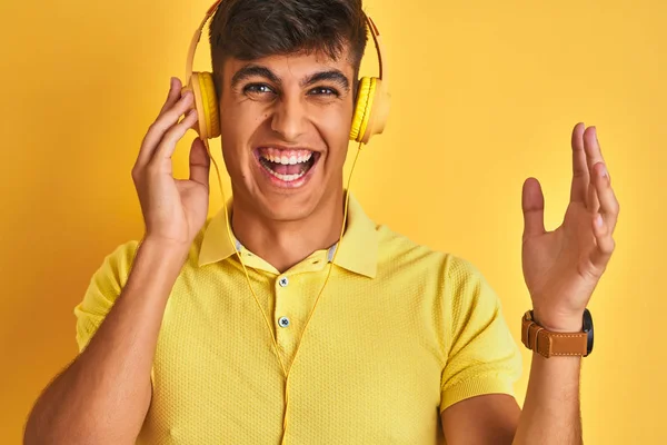 Jovem Indiano Ouvindo Música Usando Fones Ouvido Sobre Fundo Amarelo — Fotografia de Stock