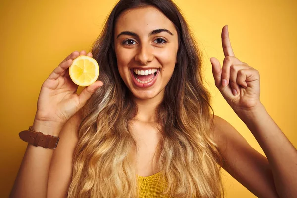 Joven Hermosa Mujer Sosteniendo Medio Limón Sobre Fondo Aislado Amarillo —  Fotos de Stock