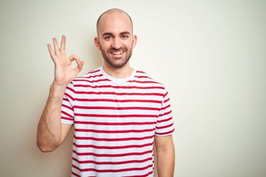 Sakallı, beyaz izole edilmiş arka planda sıradan kırmızı tişörtlü genç kel adam el ve parmaklarıyla 