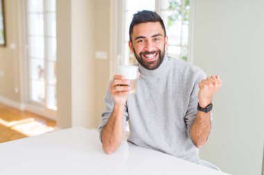 Yakışıklı İspanyol adam gurur çığlık bir fincan kahve içme ve zafer ve başarı çok heyecanlı kutluyor, duygu tezahürat