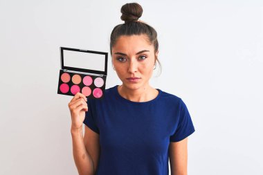 Makyajlı genç bir kadın, izole edilmiş beyaz arka planda duruyor. Zeki bir yüz ifadesiyle ciddi olduğunu düşünüyor.