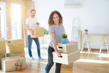 Orta yaşlı çift yeni bir eve taşınıyor. Yüzlerinde kocaman bir gülümsemeyle kameraya bakan elleri ve parmaklarıyla işaret ediyorlar..