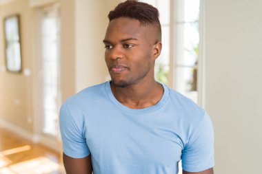 Yakışıklı Afro-Amerikan erkeği rahat bir görünüm ve kendine güvenen bir gülümseme takınıyor..