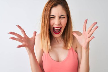 Beautiful redhead woman wearing casual pink t-shirt standing over isolated white background very happy and excited, winner expression celebrating victory screaming with big smile and raised hands