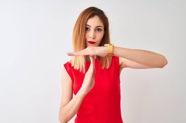 Redhead businesswoman wearing elegant red dress standing over isolated white background Doing time out gesture with hands, frustrated and serious face
