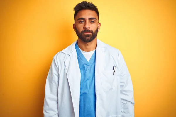 Junger Indischer Arzt Der Vor Isoliertem Gelben Hintergrund Mit Ernstem — Stockfoto