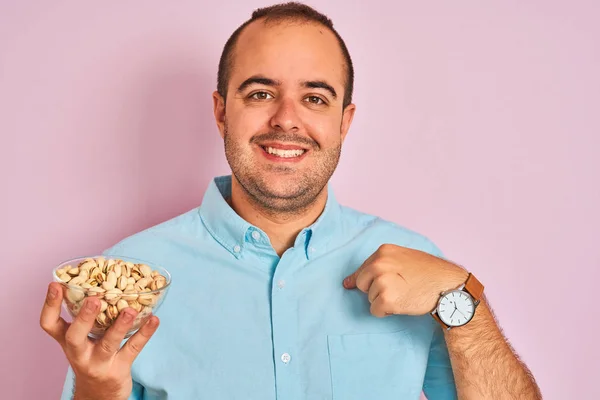 Jongeman Die Een Kom Vasthoudt Met Pistachenoten Die Een Geïsoleerde — Stockfoto