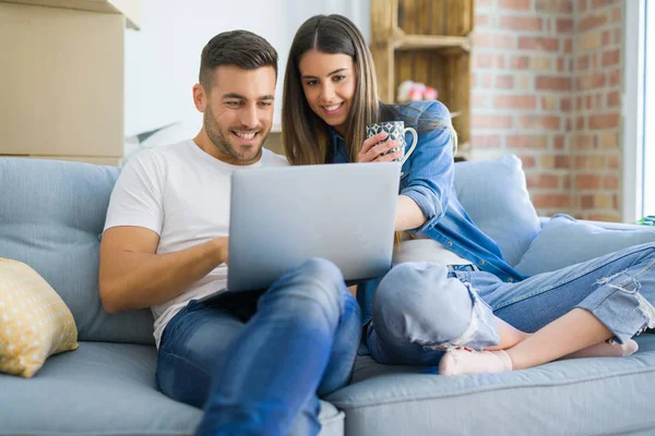 Casal jovem se mudando para uma nova casa relaxante sentado no sofá u — Fotografia de Stock