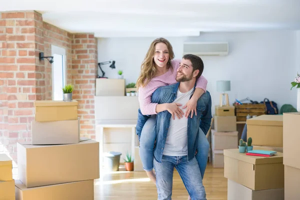 Pareja joven mudándose a una casa nueva, novio dando un bac cerdito — Foto de Stock