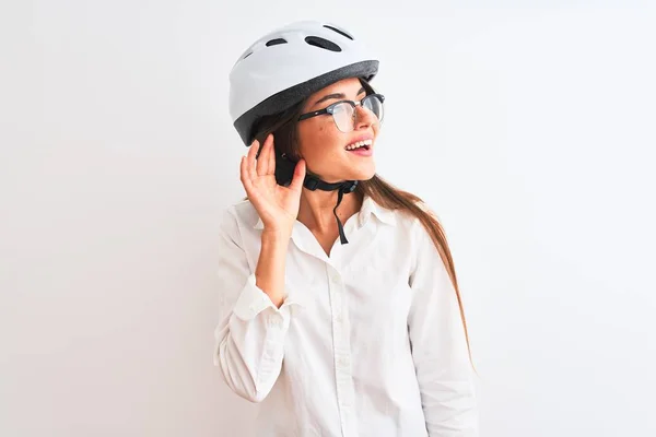 漂亮的女商人戴着眼镜 戴着自行车头盔 站在孤独的白色背景上微笑着 两手空空地听着流言蜚语 失聪的概念 — 图库照片