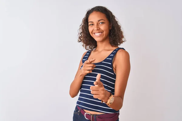 縞模様のTシャツを着た若いブラジル人女性は 幸せと面白い顔を持つカメラに指を指して孤立した白い背景の上に立っています 良いエネルギーと振動 — ストック写真