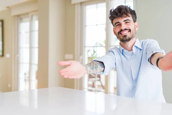 Joven Hombre Negocios Sentado Mesa Blanca Mirando Cámara Sonriendo Con —  Fotos de Stock