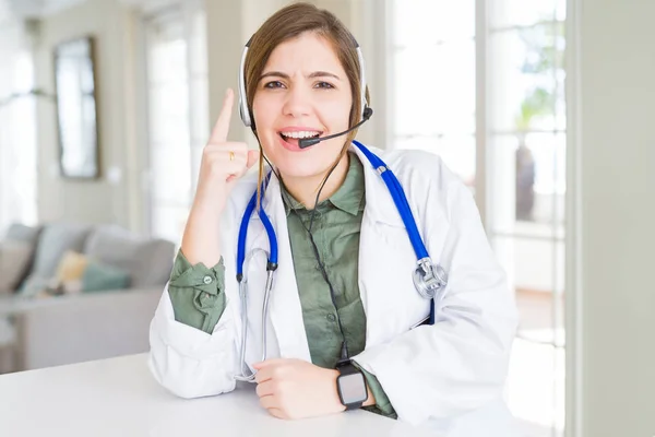 Schöne Junge Ärztin Mit Headset Zeigt Mit Erhobenem Zeigefinger Auf — Stockfoto