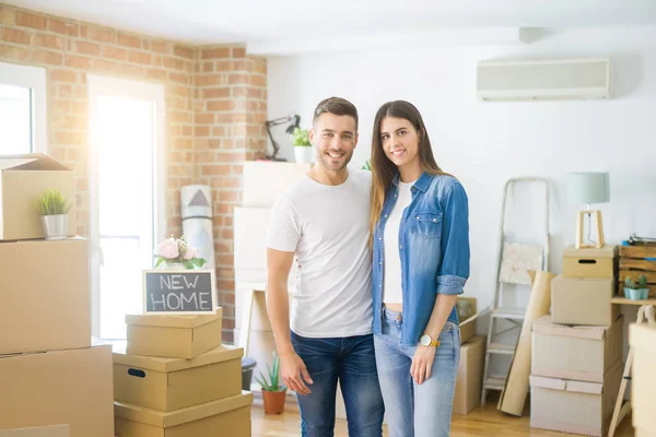 Schönes junges Paar zieht in ein neues Haus und lächelt glücklich arro — Stockfoto