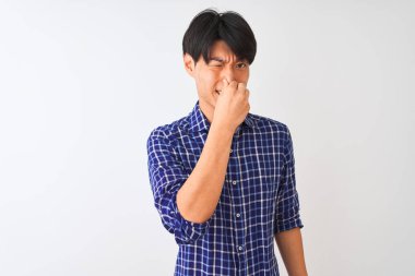 Sıradan mavi gömlekler giyen genç Çinli bir adam izole edilmiş beyaz arka planda dikiliyor pis ve iğrenç bir koku alıyor, dayanılmaz bir koku, parmakları burnunda nefesini tutuyor. Kötü koku konsepti.