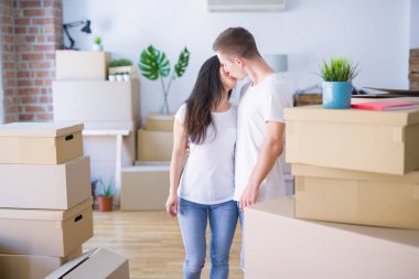 Karton kutuların etrafında duran genç ve güzel bir çift.