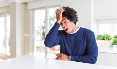 Genç Afro-Amerikan bir adam günlük süveter giyer evde oturur ve hata yaptığında şaşırır. Hatayı hatırla. Unuttum, kötü hafıza konsepti.