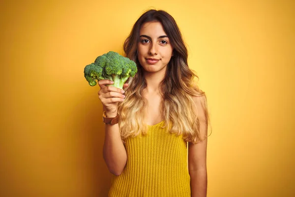 Giovane Bella Donna Mangiare Broccoli Sfondo Giallo Isolato Con Espressione — Foto Stock