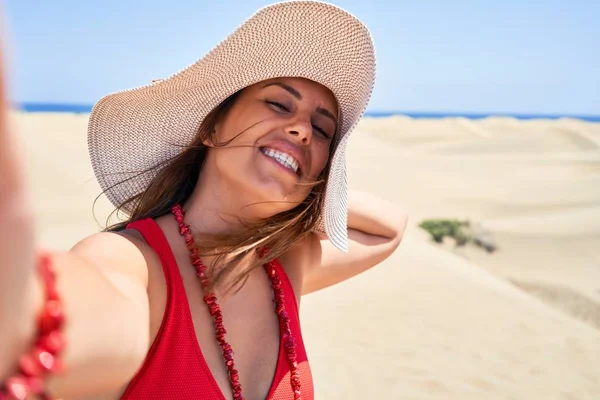 年轻漂亮的女人穿着夏装日光浴 在睫毛膏沙丘用智能手机自拍 — 图库照片