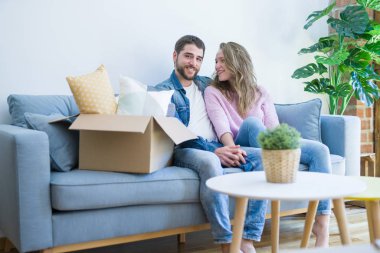 Genç çift içinde aşk sarılma oturma üzerinde the kanepe çok mutlu MOVI