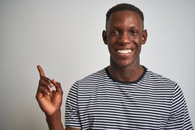 Siyah çizgili tişört giyen Afro-Amerikan bir adam izole edilmiş beyaz arka planda duruyordu. Elleri ve parmakları kenarda mutlu bir şekilde duruyordu.