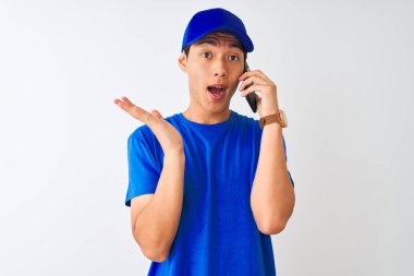 Kapüşonlu Çinli teslimatçı, kapalı beyaz arka plan üzerinden konuşuyor. Çok mutlu ve heyecanlı. Kazanan ifade zaferi büyük bir gülümsemeyle kutluyor ve ellerini kaldırıyor.