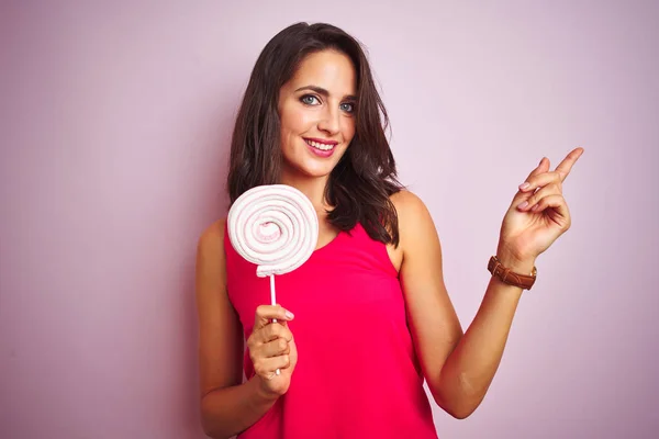 Młoda Piękna Kobieta Jedząca Słodkie Cukierki Różowym Tle Bardzo Szczęśliwy — Zdjęcie stockowe