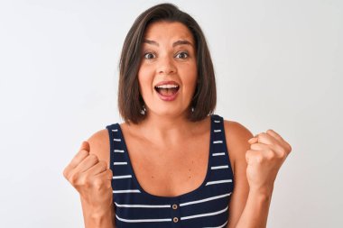 Mavi çizgili tişört giyen genç güzel bir kadın izole edilmiş beyaz arka planda durup gururla bağırıyor ve zaferi ve başarıyı kutluyor. Çok heyecanlı, coşkulu bir duygu.