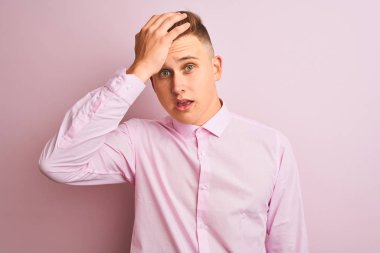 Soyutlanmış pembe arka planda duran zarif tişörtlü genç yakışıklı işadamı hata için el ele tutuşarak şaşırdı. Hatayı hatırla. Unuttum, kötü hafıza konsepti.