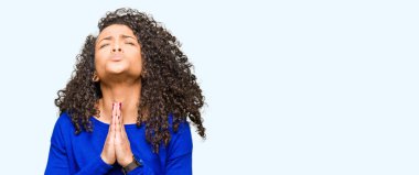 Kıvırcık saçlı genç güzel kadın kış kazak giyen dilencilik ve umut ifadesi ile birlikte elleri ile dua çok duygusal ve endişeli yüzünde. Af dilemek istiyorum. Din kavramı.